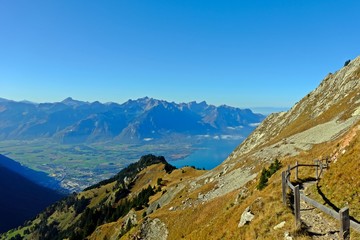 Obraz premium Trail on the peak of Rochers-de-Naye with Lake Geneva and gorgeous view of gigantic mountains as background.