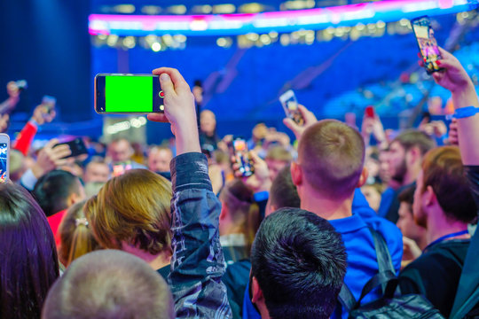 Audience at event uses smartphone camera to take photos and videos
