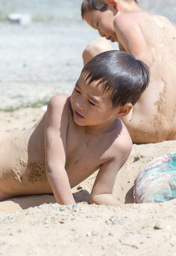 Children Lie Naked In The Sand