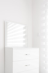 Cozy light cupboard with a mirror with white walls