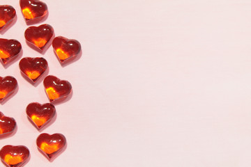 Glass red hearts on a pink background. Empty space for text and copy on the right side of the photo. Stock photo for valentine's day