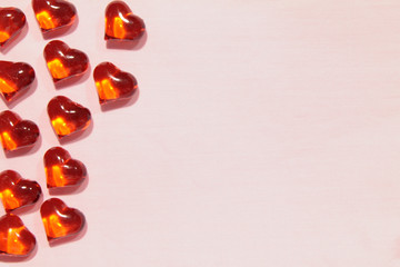 Glass red hearts on a pink background. Empty space for text and copy on the right side of the photo. Stock photo for valentine's day