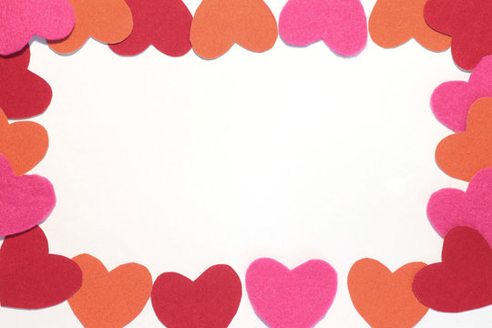 frame of red, pink and orange hearts on a white isolated background. Empty space in the center for copy and text. Valentine's Day stock photo