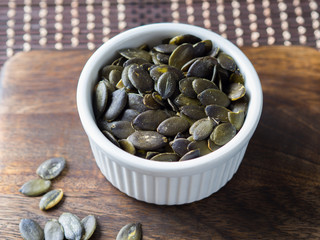 Pumpkin seeds. Vegan protein source. Healthy snack in a white ramekin