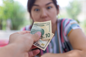 Offer dollar bills. A man offers a girl money for sex