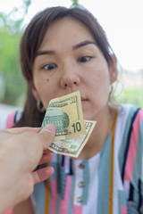 Offer dollar bills. A man offers a girl money for sex