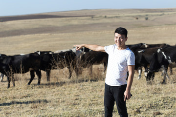 man and cow on pasture
