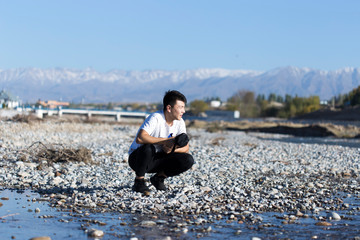 man in nature by the river with stones