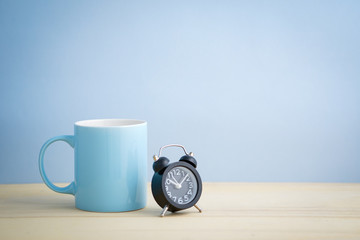 an empty pastel color mug with flower and retro clock