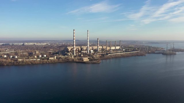 Aerial view of coal-fired power plants in a large area near the river. Camera Tracking from left to right.
