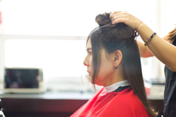 Naklejka premium Beautiful woman at the hairdresser blow drying her hair