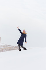 Portrait of a beautiful girl in blue jackets on the background of snow. Outdoor winter portrait