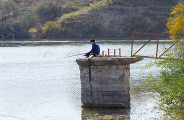 Fototapeta na wymiar a man is fishing near a river