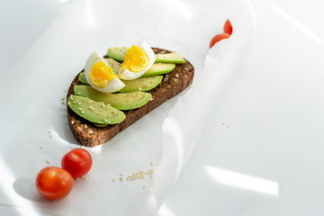 Egg and avocado sandwich.Toast with avocado and egg on rustic wooden background.