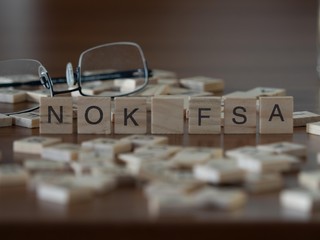 the acronym nok fsa for Finanstilsynet (FSA) concept represented by wooden letter tiles