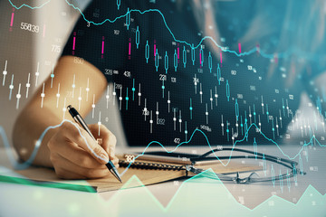 Multi exposure of woman's hands making notes with forex graph hologram. Concept of technical analysis.