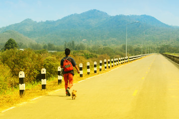 Obraz premium Running with the dog on a road with a forest background.