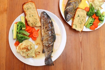 Fish dish - wood oven baked or roasted trout fish served with saute vegetables and mashed potato with copy space. Family meal
