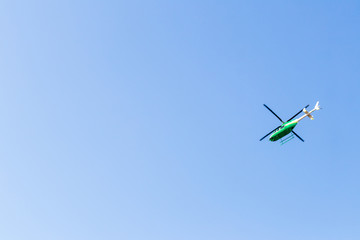 Green helicopter in the sky.