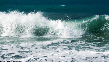 Fototapeta premium a blue sea wave hitting the shore during a small storm