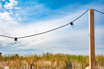 Close up of the light bulbs at the beach cafe terrace. Sunny summer day.