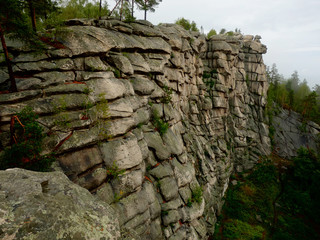  The mountain range in the form of a wall surrounded by forest. Natural landscape background.