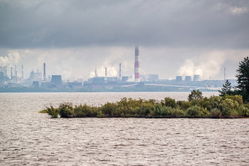 Sailing along the territory of metallurgical plant in smoke and mist 