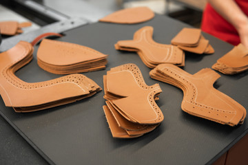 Different forms of leather pieces which will be use for making a shoes on a shoes factory. Prepared, bundled leather parts, used in the production of shoes.