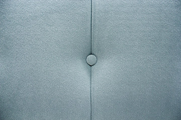 Button on the upholstery of the headboard.
