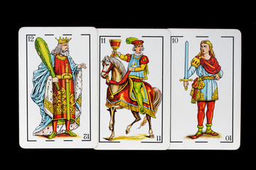 some cards from the spanish deck for playing cards games and gambling on a black background