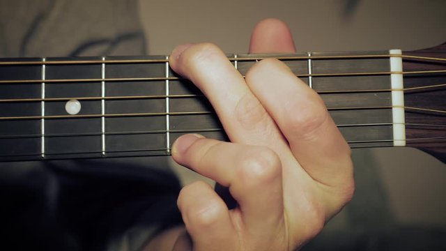 Arrangement of a G-Chord on the Guitar. Male Hand, Shaping a G Chord on the Fretboard.