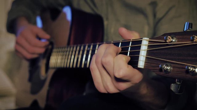 Musician Peacefully Strumming The Guitar. Focus on Left Hand Arranging Different Chords.