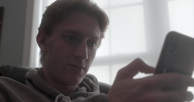 low angle teenage boy uses his smartphone
