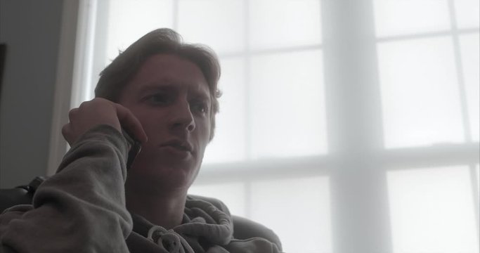 low angle teenage boy answers phone and holds conversation