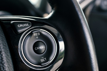 cruise control buttons on steering wheel, speed limitation system in modern car, shallow depth of...