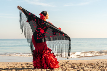 Young Spanish woman dancing flamenco on the beach - obrazy, fototapety, plakaty