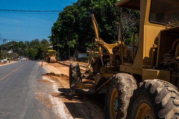 Grader is working on road construction. Grader industrial machine on construction of new roads. Heavy duty machinery working on highway. Construction equipment. Compaction of the road.