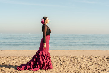 Young Spanish woman dancing flamenco on the beach