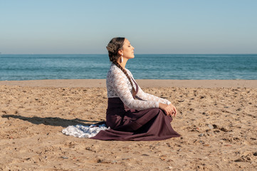 Young Spanish woman dancing flamenco on the beach
