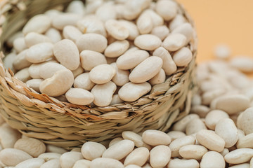 Healthy organic dried white beans in a straw basket