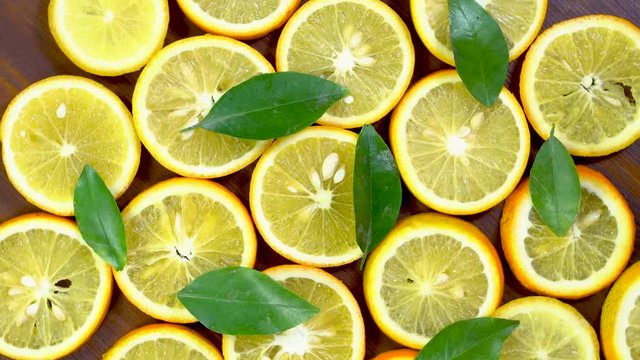 top angle shot of orange slices and fresh orange leafs in a pattern shape 4K