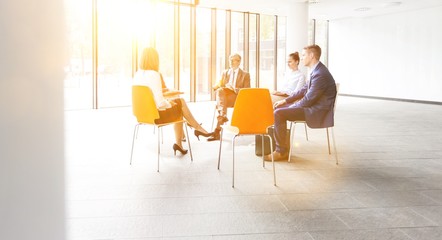 Business colleagues planning strategy while sitting on chairs during meeting
