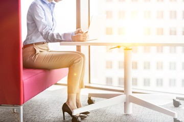 Young entrepreneur sitting while working with her laptop on a table