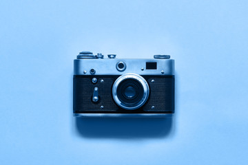 Fototapeta premium Flatlay vintage retro film camera on blue background. Copy space, top view. Minimalistic concept. Color of the year 2020 Classic Blue toned
