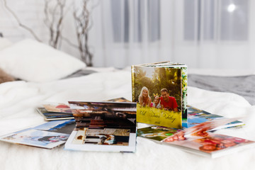 photo books lie on a white bed in the bedroom