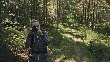 Traveler photographing scenic view in forest. One caucasian woman shooting nice magic look. Girl...