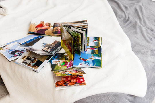 photo books lie on a white bed in the bedroom