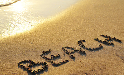  The word beach written on sand. Summertime concept.