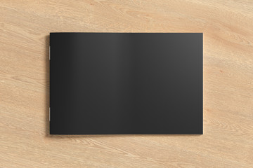 Black horizontal brochure or booklet cover mock up on wooden background. Isolated with clipping path around brochure. View above. 3d illustratuion