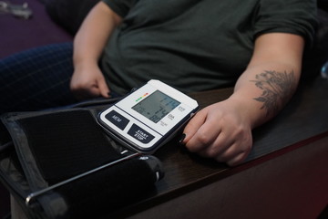 Measurement of blood pressure using a tonometer. A blood pressure monitor measures the pressure on a woman.